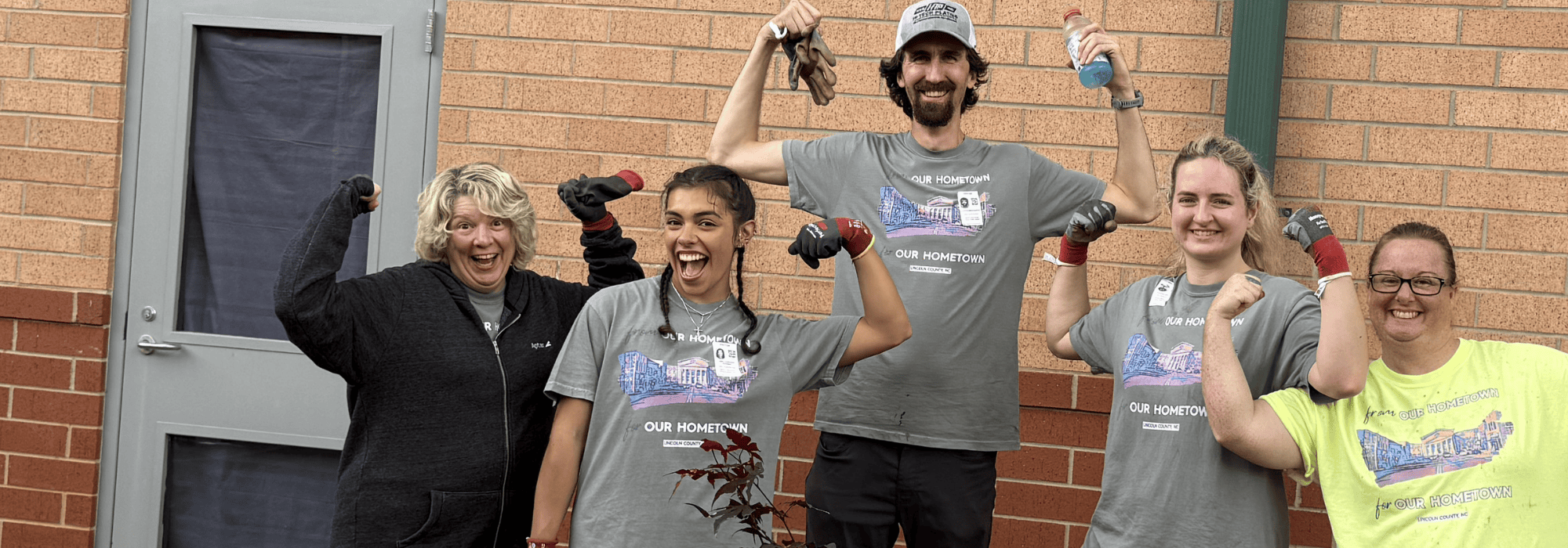 Group of United Way volunteers posing to show off their muscles