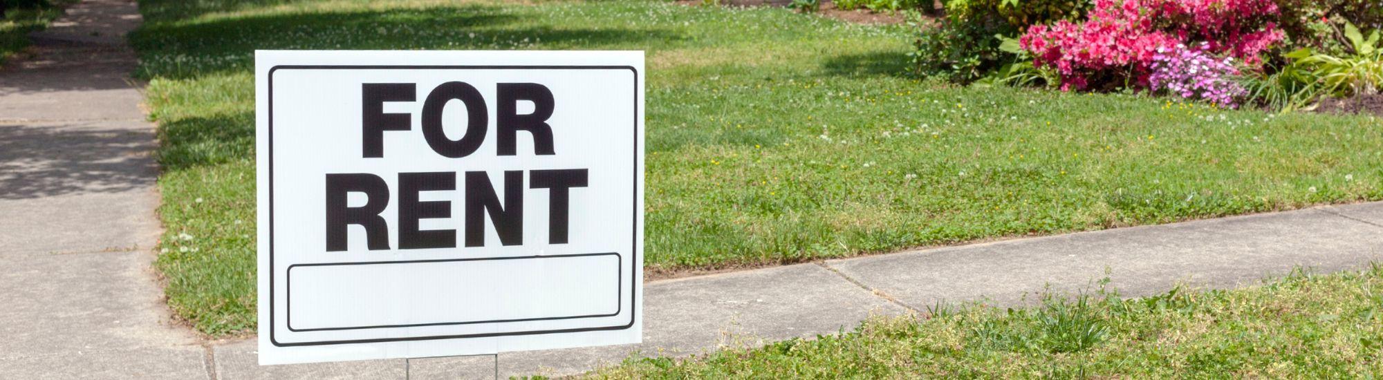 For Rent sign beside sidewalk.